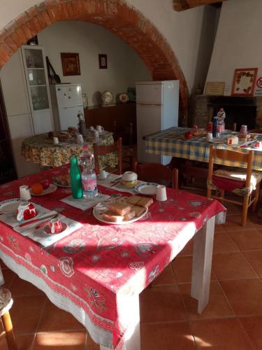a kitchen with a table with a red table cloth at Azzurre BeB in Laterina