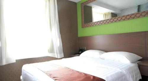 a bedroom with a large white bed with a large mirror at Largos Hotel in Hong Kong