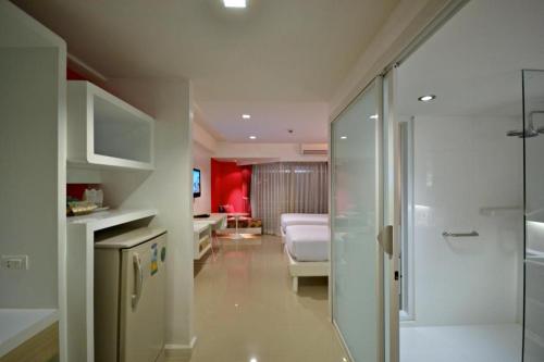 a bathroom with a shower and a bedroom with a bed at Hinn - Namm Hotel in Hua Hin