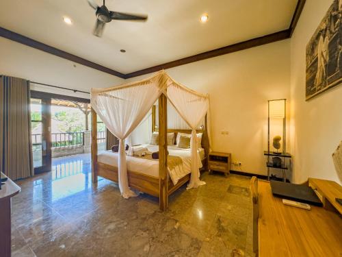 a bedroom with a bed with a canopy at Villa Blubambu in Seminyak