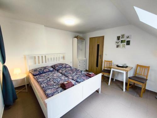 a bedroom with a bed and a table and chairs at Ubytování U Tajčů in Dolní Beřkovice