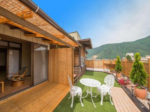 a patio with a table and chairs on a deck at Kamiyamada Hotel in Chikuma