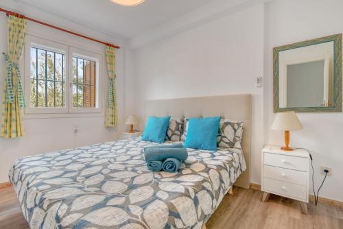 a bedroom with a large bed with blue pillows at Love Chill in Denia
