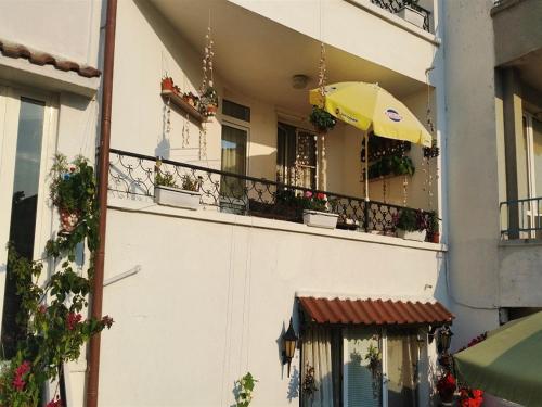 ソゾポルにあるGuest House Konomaeviの黄色い傘付きのバルコニー付きの建物