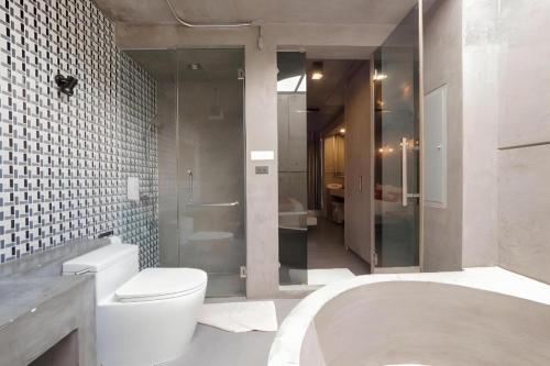 La salle de bains est pourvue d'une douche, de toilettes et d'une baignoire. dans l'établissement OYO 75368 Demadre Resort, à Bangkok
