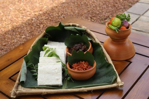 a plate of food on a table with potted plants at The Niche Hikkaduwa - 10 minutes to the beach in Hikkaduwa