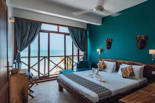 a bedroom with a bed with a view of the ocean at Pili Pili Tropical Island in Jambiani