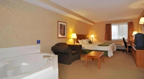 a hotel room with a bed and a bath tub at Best Western Rama Inn in Ephrata