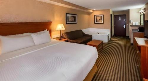 a hotel room with a bed and a bath tub at Best Western Rama Inn in Ephrata
