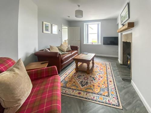 een woonkamer met een bank en een salontafel bij Guise Cottage Uk46303 in Tough