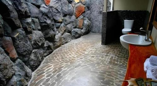 a bathroom with a stone wall and a sink at Le Manumea Hotel in Apia