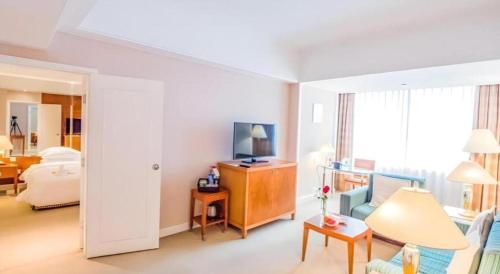 a hotel room with a bed and a living room at Kai Wah Plaza International Hotel in Kunming