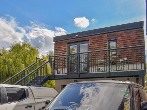 a house with a balcony and cars parked in front of it at Willows View in Etchingham