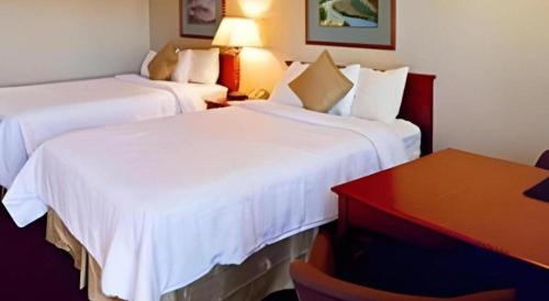 a hotel room with two beds and a desk at Airport Inn in Boise