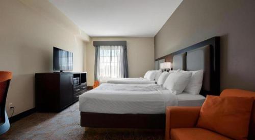 a hotel room with a large bed and a couch at Best Western Plus Executive Inn in Toronto