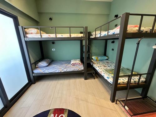 a room with three bunk beds in it at 漾漾漫旅Young B&B in Fangliao