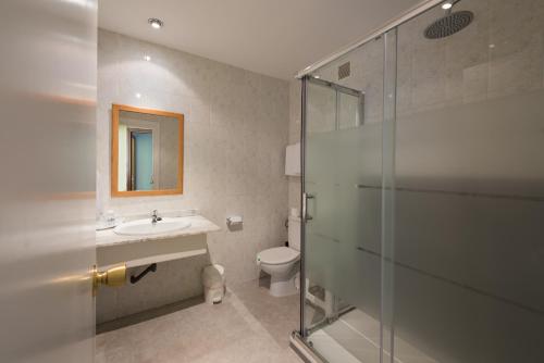 La salle de bains est pourvue de toilettes, d'un lavabo et d'une douche. dans l'établissement Hotel Marina, à Oropesa del Mar