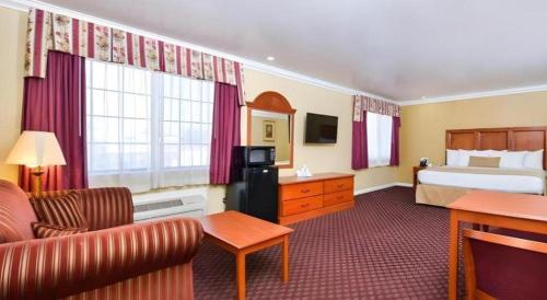 a hotel room with a bed and a couch at Best Western Hanford Inn in Hanford