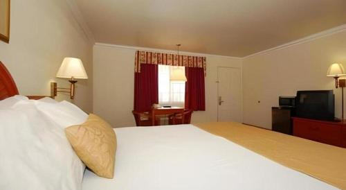 a bedroom with a large white bed and a television at Best Western Hanford Inn in Hanford