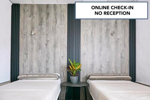two beds with a sign that reads online check in no reception at V Pension & Suites in Burriana