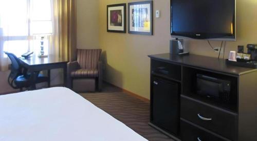 a hotel room with a bed and a flat screen tv at Quality Inn & Suites Detroit Lakes in Detroit Lakes