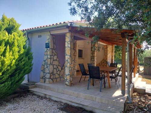 ein kleines Cottage mit einem Tisch und Stühlen auf einer Terrasse in der Unterkunft Gabriella in Valtura