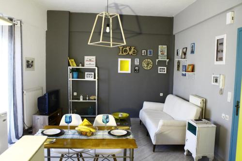 Deodonum Luxury Apartments في مدينة هيراكيلون: غرفة معيشة مع أريكة وطاولة
