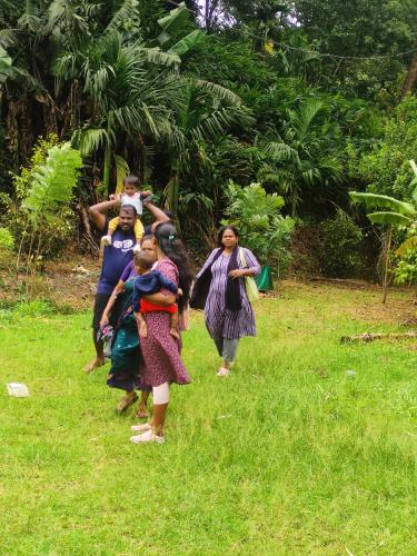 a group of women walking in the grass at Munnar Village Homes in Munnar