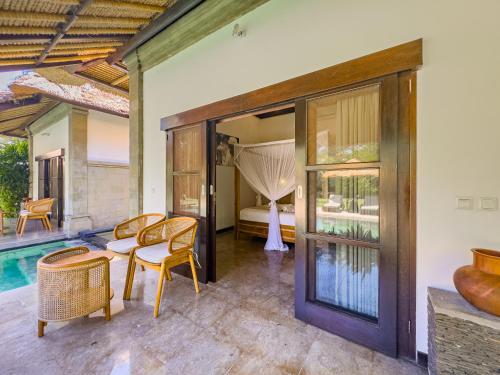 a villa with a pool and a bedroom at Villa Blubambu in Seminyak
