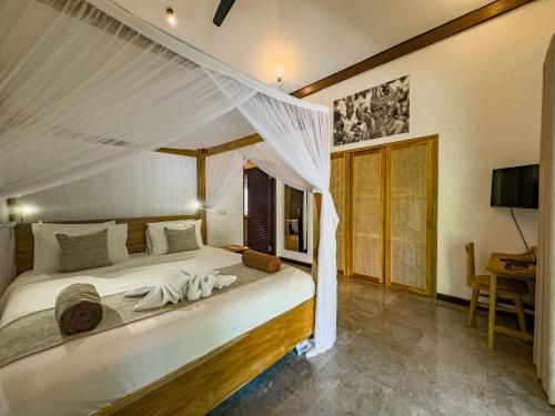 a bedroom with a large bed with a canopy at Villa Blubambu in Seminyak