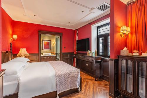 a bedroom with red walls and a bed and a television at Beijing Xiaofengxian Former Residence Hotel Tiananmen Square Qianmen Store in Beijing