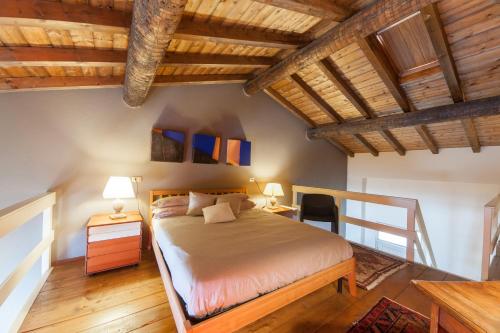 a bedroom with a bed and a wooden ceiling at Nest on The Lake in Marone