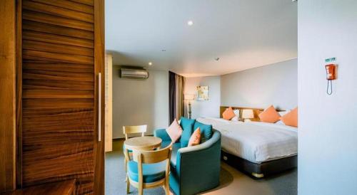 a hotel room with a bed and a couch and a chair at Hotel One Byeonsan in Buan