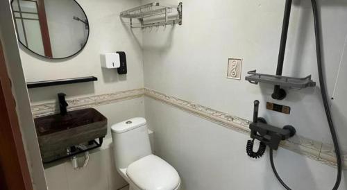 a bathroom with a white toilet and a mirror at New Mong Kok Guest House in Hong Kong