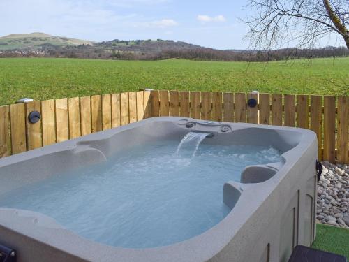 a hot tub in a backyard with a fence at Pinewood Cabin in Saline