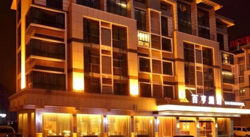 a tall building with lights in front of it at night at Yiwu Baiheng Hotel in Yiwu