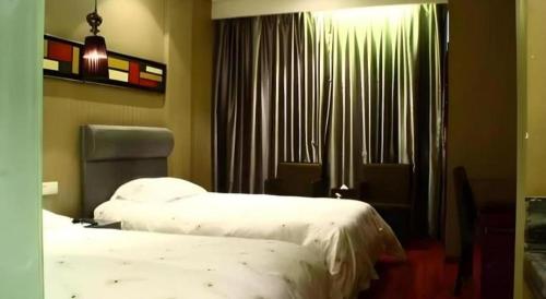 a hotel room with two beds and a window at Yiwu Baiheng Hotel in Yiwu