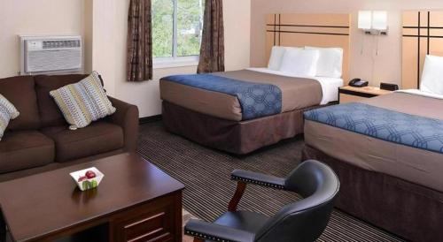 a hotel room with a couch and a bed at Econo Lodge Rochester I-90 & I-390 in Rochester