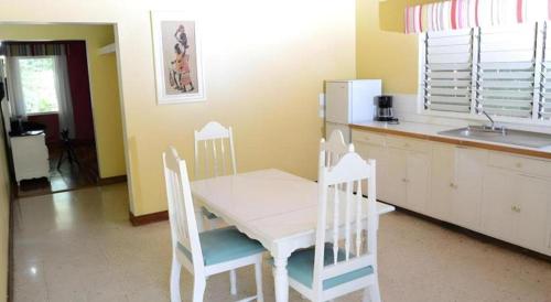 a kitchen with a table and chairs and a sink at Gold Nugget Hotel in Negril