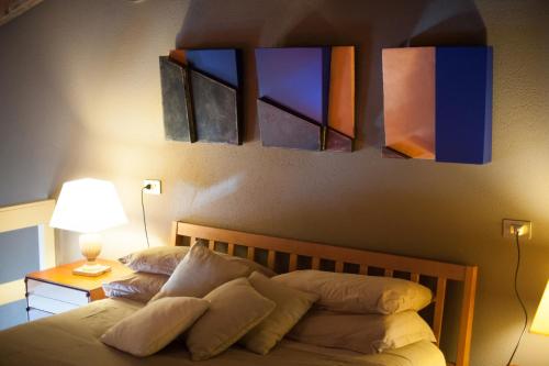 a bedroom with a bed with paintings on the wall at Nest on The Lake in Marone