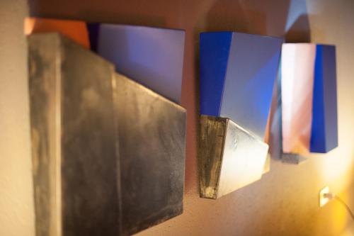 a row of blue and white objects on a wall at Nest on The Lake in Marone