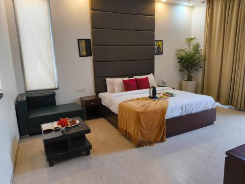 a bedroom with a bed and a table and a chair at Hotel Florence near Artemis Hospital in Gurgaon