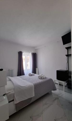 a white bedroom with a bed and a window at La rosa dei pepoli in Castiglione dei Pepoli