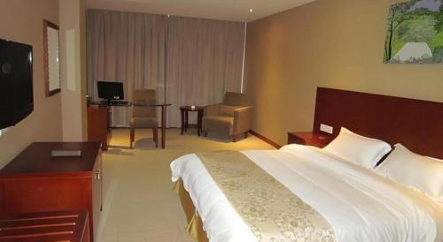 a hotel room with a large bed and a desk at Super 8 Hotel Quanzhou Xinchezhan Branch in Quanzhou