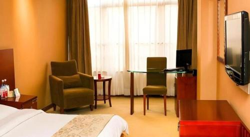 a hotel room with a bed and a table and chairs at Super 8 Hotel Quanzhou Xinchezhan Branch in Quanzhou