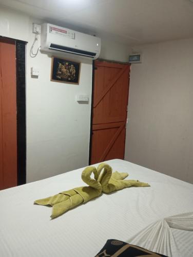 a yellow ribbon sitting on top of a bed at Sigiri Royal Point Tree House in Sigiriya