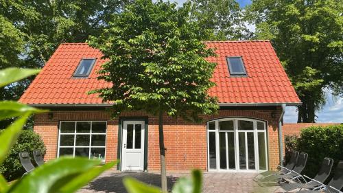 a small brick house with an orange roof at Meine Schule Sehlingen, Dein Hideaway für ZWEI, Land- oder Radurlaub in der Lüneburger Heide, Nordpfade, Workation mit Sauna, Ruhe & Erholung oder Niedersachsen Städte wie Hamburg, Hannover, Bremen und Verden entdecken in Kirchlinteln