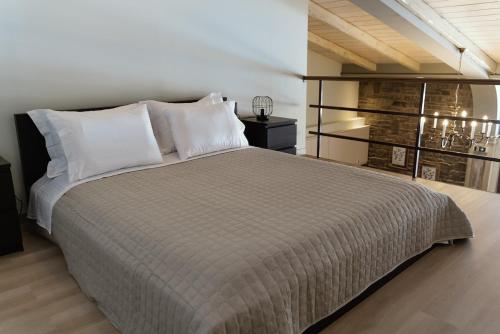 a bedroom with a large bed with white pillows at LOTOS Families Apartments 2 in Konitsa