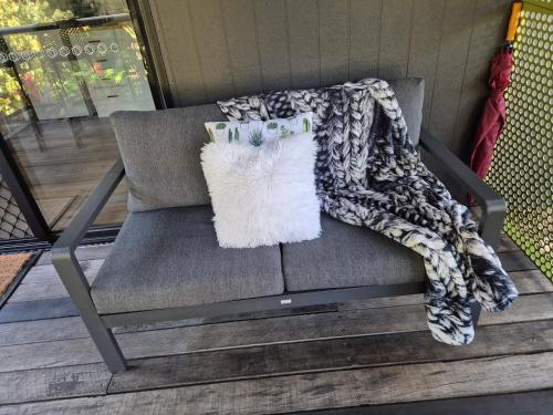 a blanket sitting on a chair with a pillow at Greenhills Retreat in Kuranda