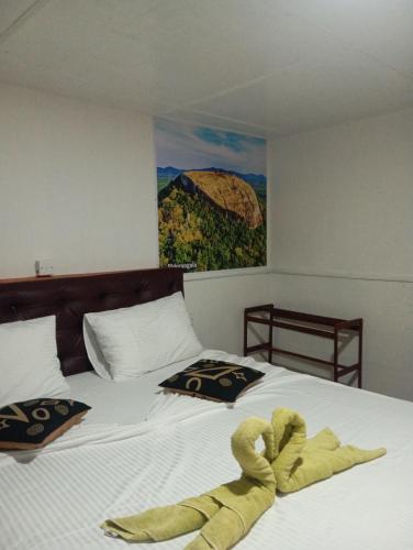 a bed with a towel laying on top of it at Sigiri Royal Point Tree House in Sigiriya